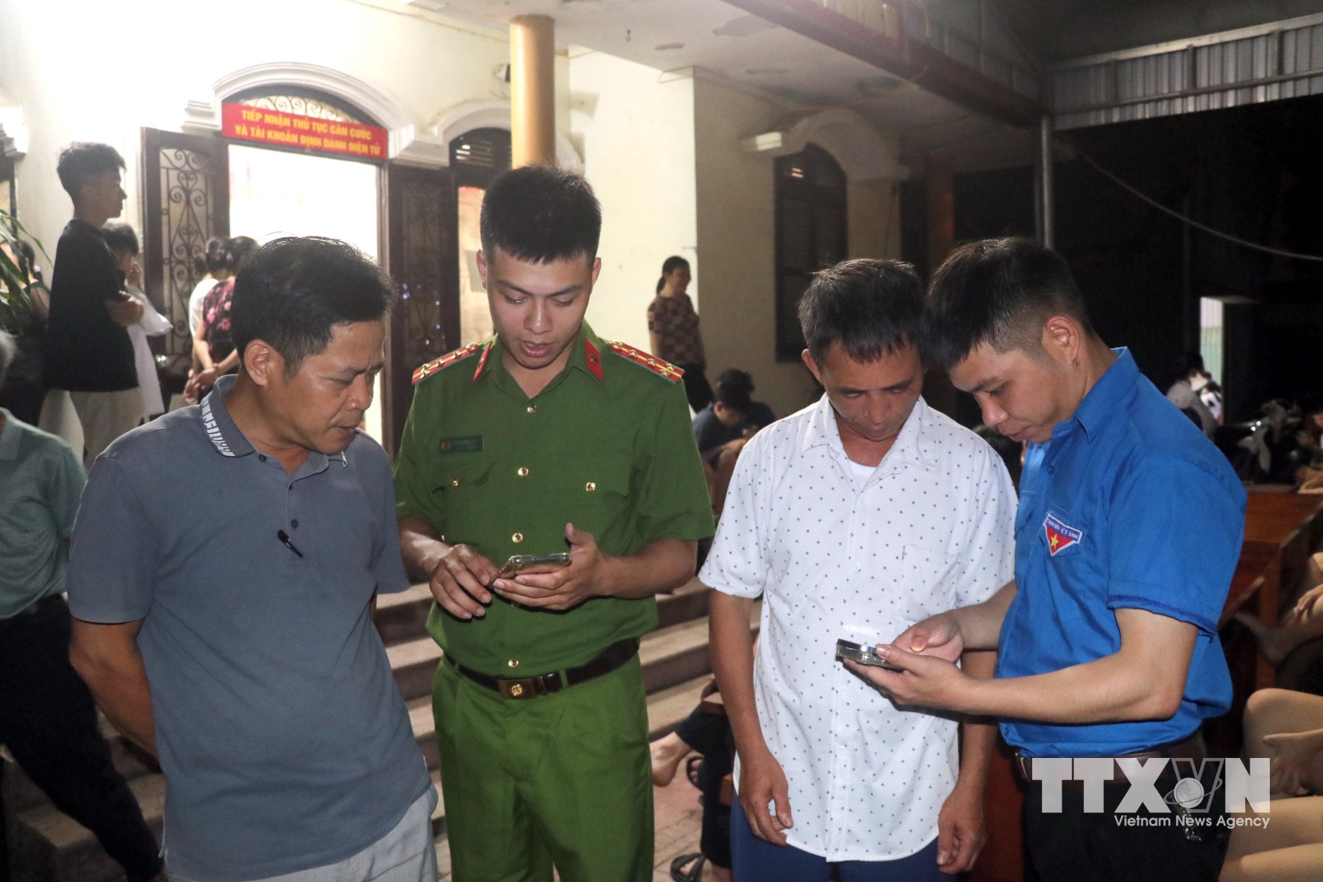 Lực lượng Công an xã Hưng Hà phối với Đoàn Thanh niên xã hướng dẫn người dân cài đặt, sử dụng ứng dụng "Báo cháy 114" trên điện thoại di động. (Ảnh: Đinh Văn Nhiều/TTXVN)